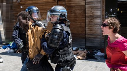 Des CRS &eacute;vacuent un migrant pr&egrave;s de la halle Pajol, &agrave; Paris, le 8 juin 2015. (LAURENCE GEAI / SIPA)