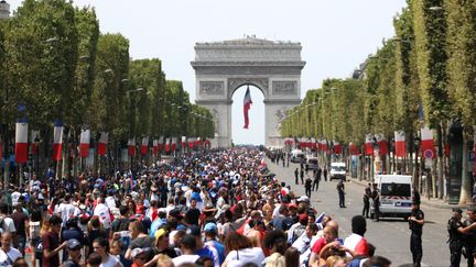 Les supporters français attendent l'arrivée des Bleus sur les Champs-Elysées, à Paris, le 16 juillet 2018. (ZAKARIA ABDELKAFI / AFP)