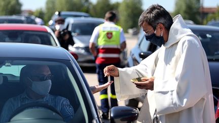 Un prêtre donne la communion à un fidèle, le 17 mai 2020 à Châlons-en-Champagne (Marne). (FRANCOIS NASCIMBENI / AFP)