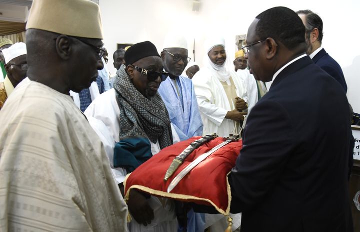 Le sabre d'Omar Saïdou Tall, une pièce de fer, de laiton, de cuivre, de cuir et de bois avec son étui faisant partie des collections du Musée de l'armée à Paris.&nbsp;Le président Macky Sall (à droite de l'image) l'a reçu&nbsp;à Dakar le 17 novembre 2019. (SEYLLOU / AFP )