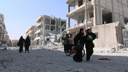 Des habitantes de Minbej (Syrie) dans la rue après la libération de leur ville par les&nbsp;Forces démocratiques syriennes, le 12 août 2016. (RODI SAID / REUTERS)