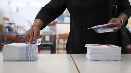 Chaque électeur doit prendre a minima deux bulletins de vote avant d'entrer dans l'isoloir (photo d'illustration). (RICHARD BOUHET / AFP)