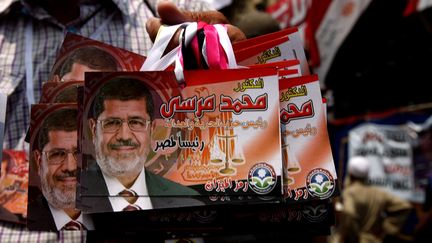 Un supporter du candidat des Fr&egrave;res musulmans Mohammed Morsi vend des images de son favori, place tahrir, au Caire, le 23 juin 2012. (MARWAN NAAMANI / AFP)