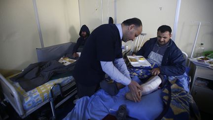 Un docteur syrien soigne un Syrien blessé dans une petite clinique à la frontière turco-syrienne, près de Kilis (Turquie), le 9 février 2016. (OSMAN ORSAL / REUTERS)