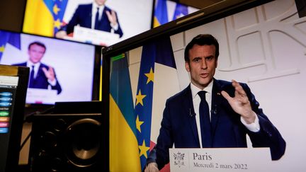 Les images des moniteurs télés lors de l'allocution du président Emmanuel Macron, le 2 mars 2022. (LUDOVIC MARIN / AFP)