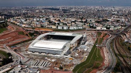 Trois ouvriers ont déjà trouvé la mort sur ce chantier lors d’accidents qui ont mis en lumière la question des retards dans les travaux et de course contre la montre engagée pour y remédier. Les responsables assurent que le stade sera livré à temps mais inachevé.
 
Le stade «n’est pas assez sûr pour recevoir du public» et ses installations «ne cadrent pas avec la législation» de l’Etat de São Paulo, a estimé un responsable des pompiers, Sidnei Turato.
 
La Banque nationale de développement devrait réinjecter 80 millions d'euros au montant initial de 247. Le financement des travaux restent flou.
 
Le stade d'une capacité de 68.000 spectateurs accueillera la cérémonie d’ouverture du Mondial. (REUTERS / Paulo Whitaker)