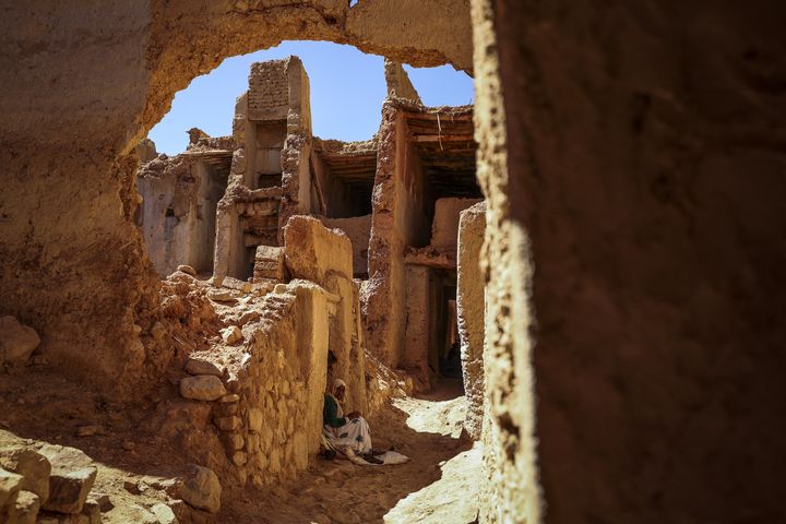 Une femme est assise dans une ruelle du quartier juif, ou mellah, du village de Tagadirt dans la région oasienne de Tata au Maroc, le 28 février 2023. (FADEL SENNA / AFP)