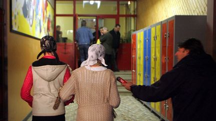 Dounia (à gauche) et Khouloud, deux élèves du collège Jean Macé (Mulhouse), à la sortie du conseil de discipline suite à leur refus d'ôter leur voile, en octobre 2004. (DAREK SZUSTER / MAXPPP)