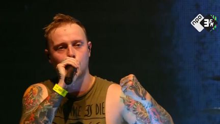 Capture d'écran de la vidéo où l'on voit Sam Carter, le chanteur du groupe Architects, interrompre son concert pour dénoncer une agression sexuelle. (NPO 3FM / TWITTER.COM)