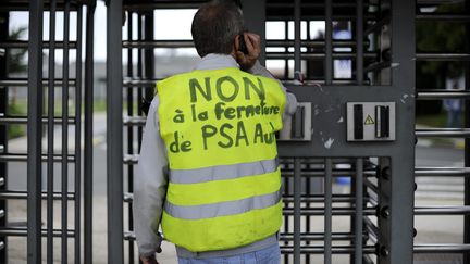 Un employ&eacute; du site PSA d'Aulnay-sous-Bois manifeste contre l'annonce de la fermeture de l'usine en 2014, le 12 juillet 2012.&nbsp; (YOAN VALAT / MAXPPP)