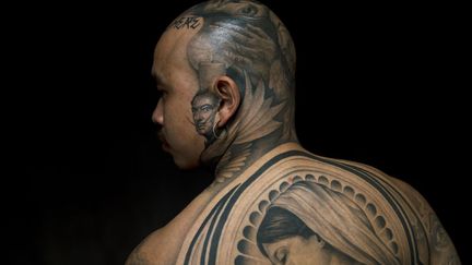 Un homme d&eacute;voile ses tatouages &agrave; l'International London Tattoo Convention de Londres (Royaume-Uni), le 28 septembre 2012. (ADRIAN DENNIS / AFP)