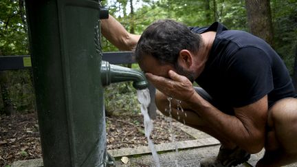 Un homme s'hydrate à une fontaine à eau, à Châtenay-Malabry (Hauts-de-Seine), le 21 août 2023. (MAGALI COHEN / HANS LUCAS / AFP)