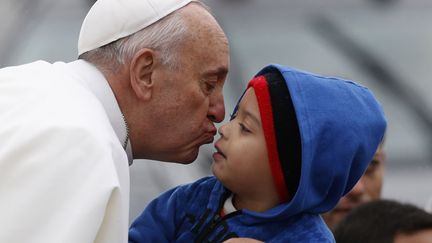 Le pape Fran&ccedil;ois embrasse un jeune gar&ccedil;on &agrave; son arriv&eacute;e au&nbsp;sanctuaire de Notre-Dame de Aparecida &agrave; Sao Paulo (Br&eacute;sil), le 24 juillet 2013. (STEFANO RELLANDINI / REUTERS)