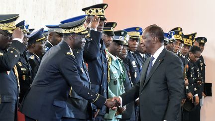 Le président ivoirien Alassane Ouattara serrant la main du chef des forces armées ivoiriennes, le 4 janvier 2018. (SIA KAMBOU / AFP)