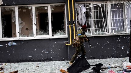 Un soldat ukrainien patrouille dans une rue de Bucha, au nord-ouest de Kiev, le 2 avril 2022. Le maire de la ville a déclaré que 280 personnes avaient été enterrées dans une fosse commune et que la ville était jonchée de cadavres. (RONALDO SCHEMIDT / AFP)