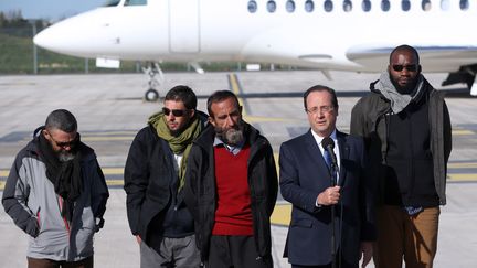 Fran&ccedil;ois Hollande &agrave; l'arriv&eacute;e de&nbsp;Marc Feret, Pierre Legrand, Daniel Larribe and Thierry Dol (de gauche &agrave; droite), le 30 octobre 2013 sur l'a&eacute;roport de&nbsp;Villacoublay (Yvelines).&nbsp; (KENZO TRIBOUILLARD / AFP)