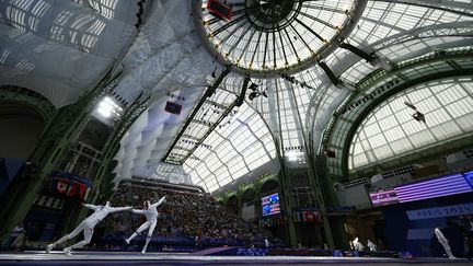 Combat individuel de titans dans l'enceinte du Grand Palais entre les épéistes vénézuéliens Grabiel Lugo et le Canadien Nicholas Zhang, le 28 juillet 2024. (FABRICE COFFRINI / AFP)