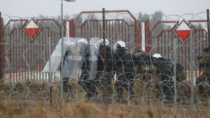 Des agents des forces de l'ordre polonaises au poste frontière de Bruzgi-Kuznica, à la frontière entre la Pologne et la Biélorussie, le 16 novembre 2021. (LEONID SHCHEGLOV / BELTA / AFP)