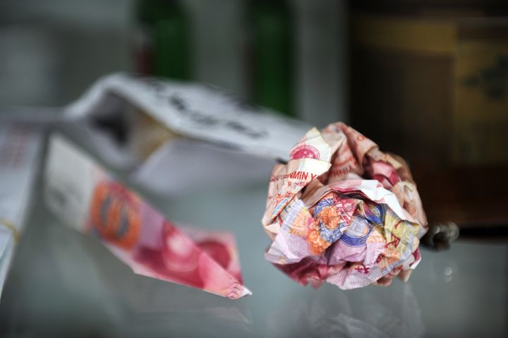 Des billets de 100 yuans roul&eacute;s en boule avant d'&ecirc;tre jet&eacute;s derri&egrave;re l'enceinte du studio d'Ai Weiwei, &agrave; P&eacute;kin, le 9 novembre 2011. (PETER PARKS / AFP)