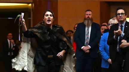 La sénatrice australienne Lidia Thorpe perturbe les débats alors que le roi Charles III et la reine Camilla de Grande-Bretagne assistent à une réception parlementaire au Parlement de Canberra, le 21 octobre 2024. (LUKAS COCH / AFP)