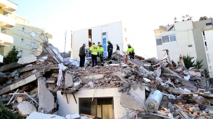 Des sauveteurs s'affairent sur les décombres d'un immeuble détruit par un séisme, à Durrës (Albanie), le 26 novembre 2019. (GENT SHKULLAKU / AFP)