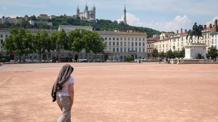 Une femme traverse la place Bellecour à Lyon, le 22 juin 2017, sous des températures atteignant 40°C. (FRANCK CHAPOLARD / CROWDSPARK / AFP)