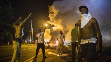 Des manifestants font face &agrave; des tirs de gaz lacrymog&egrave;ne, le 18 ao&ucirc;t 2014. ( LUCAS JACKSON / REUTERS )