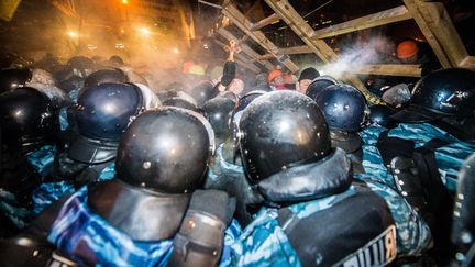 Des policiers assi&egrave;gent une barricade dress&eacute;e par des manifestants place de l'Ind&eacute;pendance &agrave; Kiev (Ukraine), le 11 d&eacute;cembre 2013. (DMITRY SEREBRYAKOV / AFP)