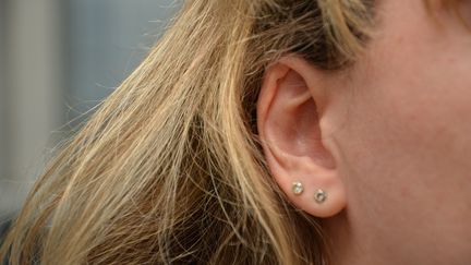 L'oreille droite d'une jeune femme agrémentée de deux bijoux. (JEAN-CHRISTOPHE BOURDILLAT / RADIO FRANCE)