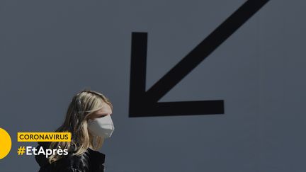 Une jeune femme devant un panneau publicitaire à Kiev (Ukraine), le 6 avril 2020. (SERGEI SUPINSKY / AFP)