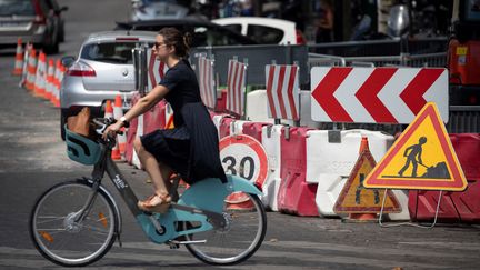 Une&nbsp;cycliste dans une rue en travaux, à Paris, en juillet 2019. (THOMAS SAMSON / AFP)