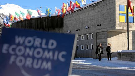 Des passants circulent devant le Centre des congr&egrave;s de Davos (Suisse), la veille de l'ouverture de la 44e &eacute;dition du Forum &eacute;conomique mondial, mardi 21 janvier 2014. ((NOTIMEX / AFP))