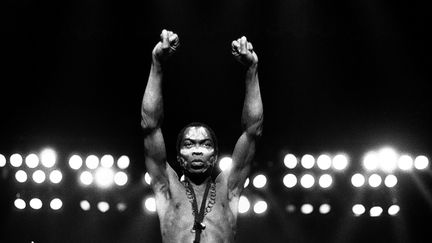 Le musicien nigérian engagé Fela Anikulapo Kuti, sur scène le 7 novembre 1986 à Detroit (Michigan, Etats-Unis),&nbsp;les deux poings brandis vers le ciel, un geste emprunté au Black Power américain. (LENI SINCLAIR / MICHAEL OCHS ARCHIVES / GETTY IMAGES)