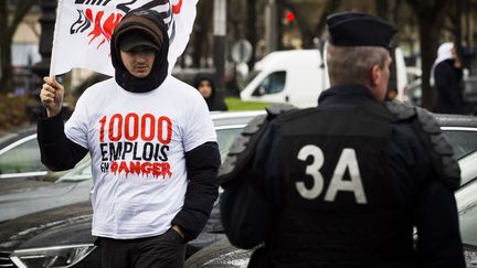 Un chauffeur de VTC&nbsp;face à un CRS, place de la Nation, à Paris, mardi 9 février 2016.&nbsp; (GEOFFROY VAN DER HASSELT / AFP)