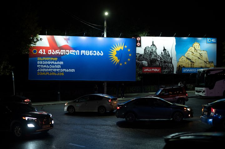 Une affiche électorale de Rêve géorgien mêle le logo du parti et les étoiles de l'UE, le 13 octobre 2024 à Tbilissi. A droite, une image d'église détruite en Ukraine, accompagnée du slogan "Dites non à la guerre, choisissez la paix". (MAURIZIO ORLANDO / HANS LUCAS / AFP)