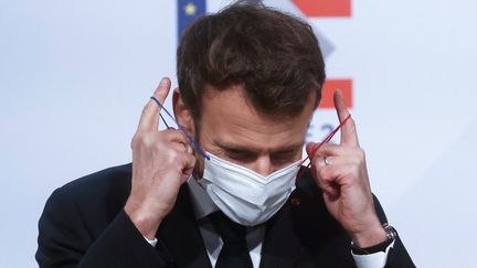 Emmanuel Macron enlève son masque avant un discours à Tourcoing, le 2 février 2022. (YOAN VALAT / POOL)